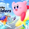 Una scena di gameplay frenetica di Kirby Air Riders, che mostra Kirby e altri personaggi su vari veicoli che usano le loro abilità in una pista colorata, con il logo di Nintendo Switch 2.